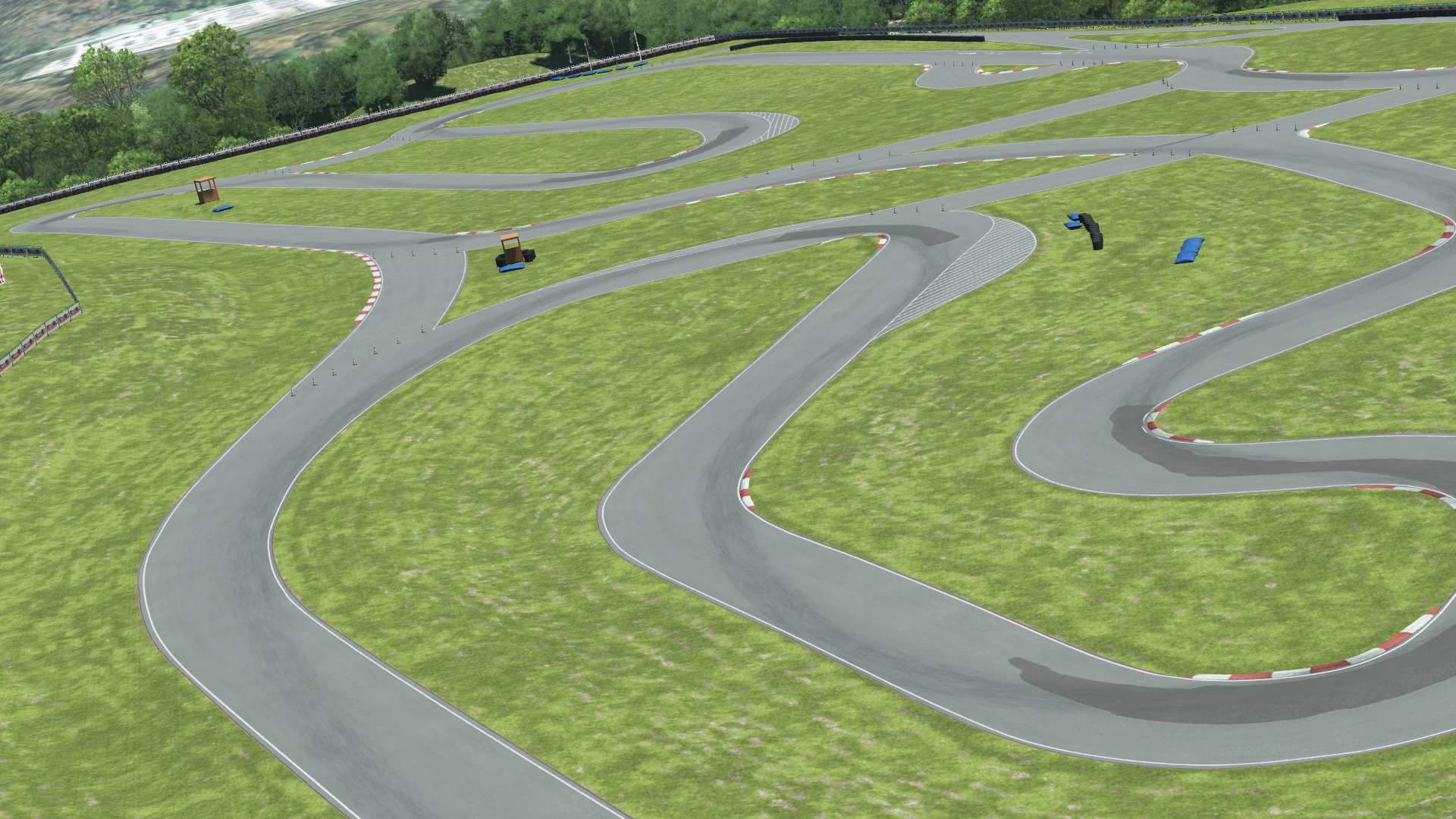 Aerial render of Pitt Race karting circuit – winding track layout with red and white kerbs, cones, barriers, and grassy surroundings