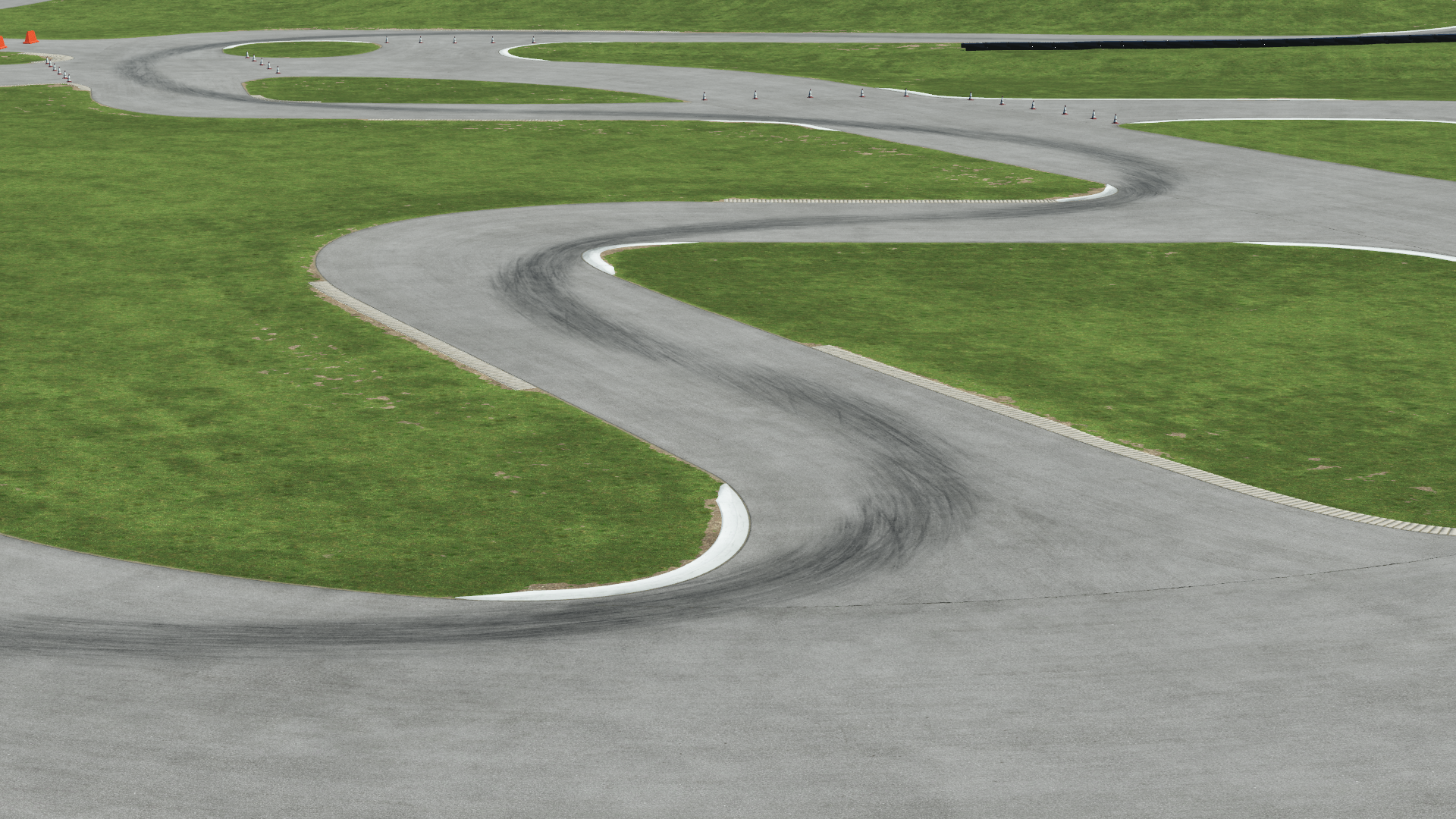 Winding karting circuit with tight S-turns and green grass surroundings