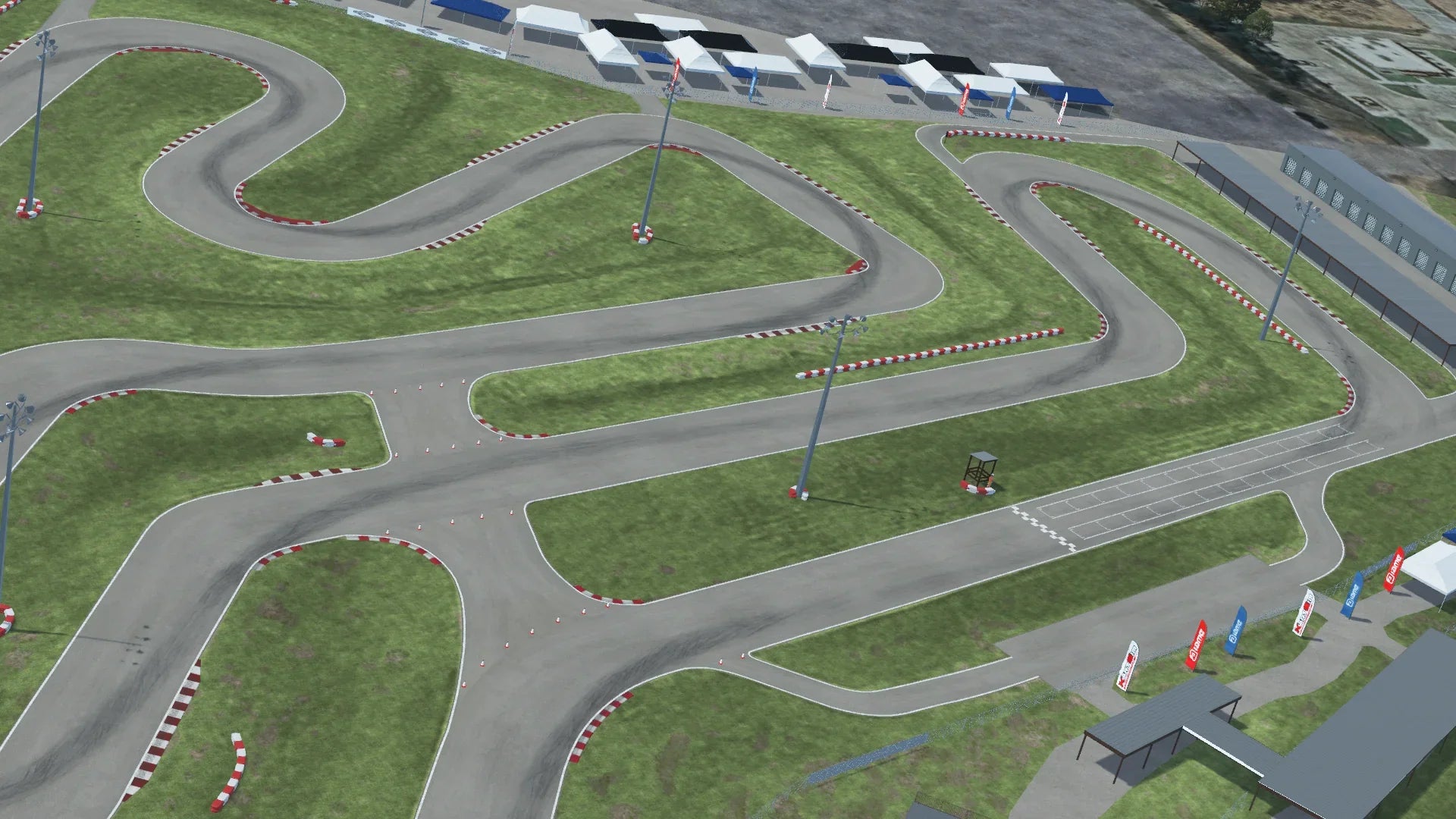 Aerial view of Speedsportz karting track with winding turns, red and white curbs, and grass infield, surrounded by paddock tents